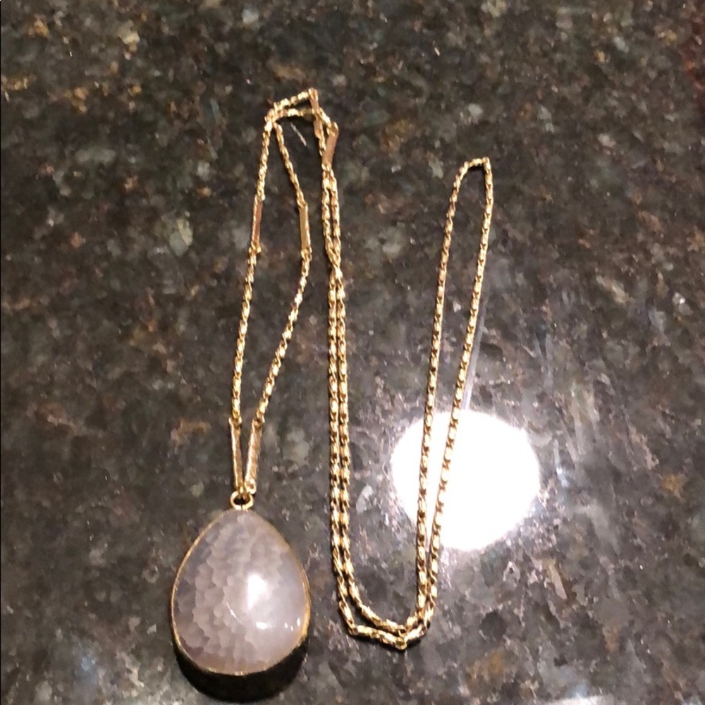 Gold necklace with grey stone.